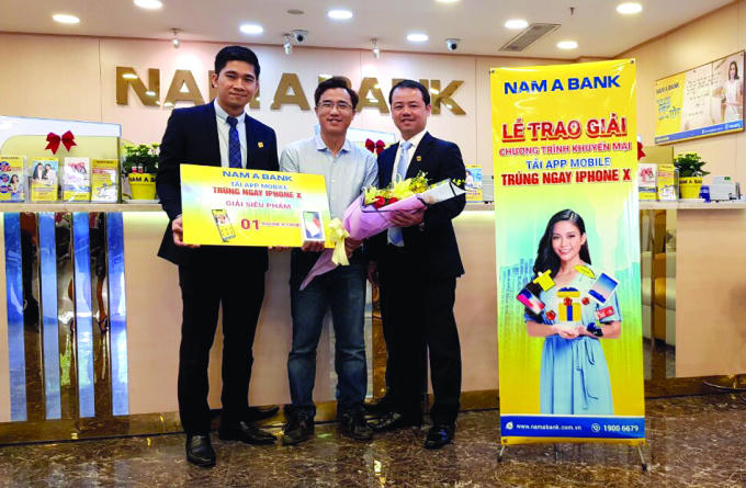 Ông Nguyễn Quang Thông - Giám đốc Trung tâm Ngân hàng số và ông Nguyễn Quốc Khánh - Giám đốc Nam A Bank Hòa Bình trao giải Siêu phẩm là 1 chiếc iPhone X cho Khách hàng Nguyễn Ngọc Dương.