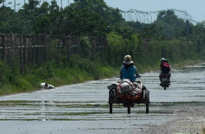 Đại lộ Thăng Long làn dành cho xe thô sơ nắng rát khiến mặt đường bốc hơi, phản chiếu như vừa mưa xong. Ảnh: Ngọc Thành