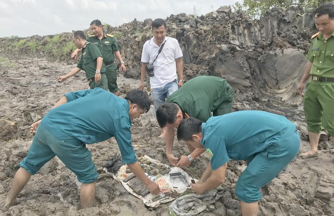 Lực lượng chức năng kiểm tra hiện trạng các loại vũ khí nguy hiểm vừa được người dân phát hiện. Ảnh: K.V