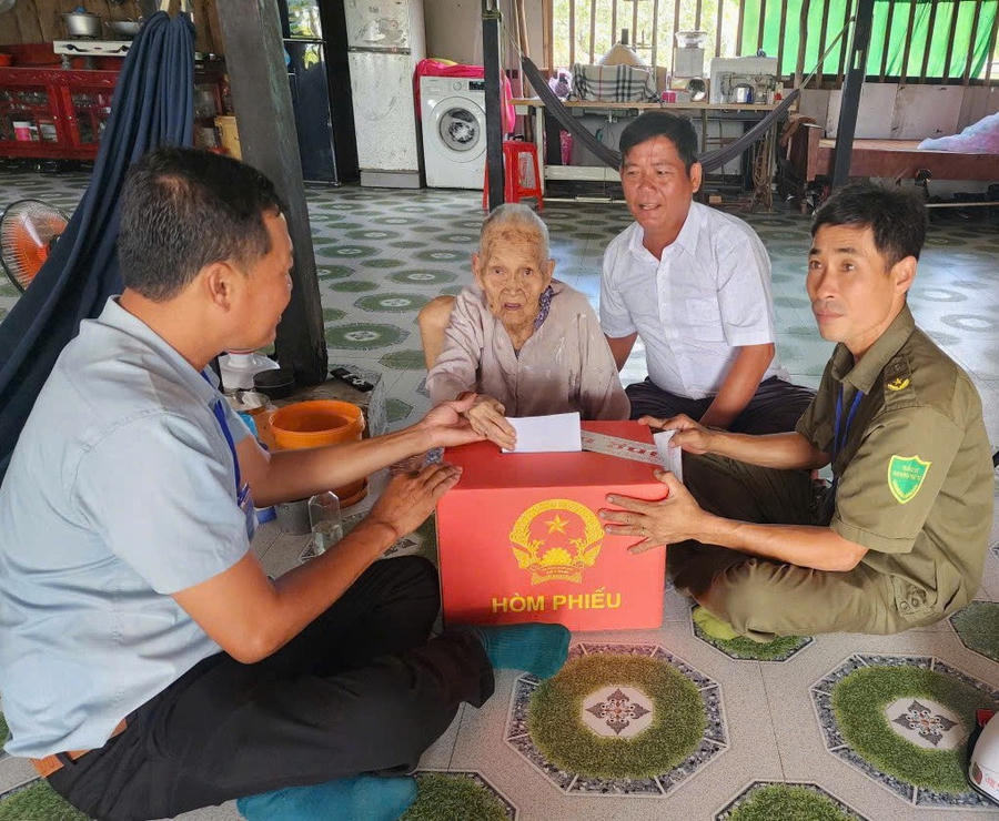 Bà Lý Thị Vãi (SN 1930), ngụ ấp Tân Quảng Tây, xã Cái Đôi Vàm thực hiện quyền bầu cử tại nhà thông qua hòm phiếu lưu động.