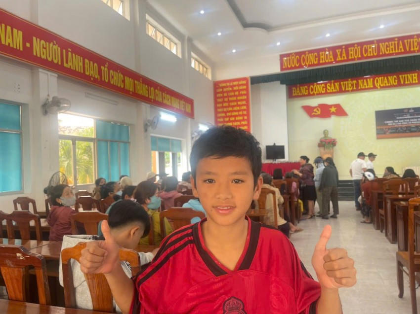 Em Phong (học sinh lớp 7, Trường THCS Nguyễn Thị Định) không giấu được niềm vui khi được đến nhận phần quà Tết từ chương trình. Nụ cười rạng rỡ và cái giơ tay đầy hào hứng của em như gửi gắm mong ước về một mùa xuân ấm áp, đủ đầy hơn sau những ngày gia đình chịu ảnh hưởng bởi mưa lũ.