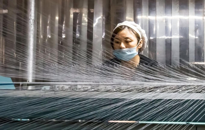Một nữ nhân công đang làm việc trong một nhà máy dệt ở phía Đông tỉnh Giang Tô, Trung Quốc (Ảnh: AFP / Getty Images)