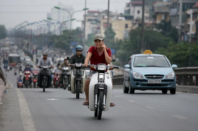 Từ 1/8, đi xe máy nghe điện thoại di động bị phạt tiền. Ảnh minh họa.