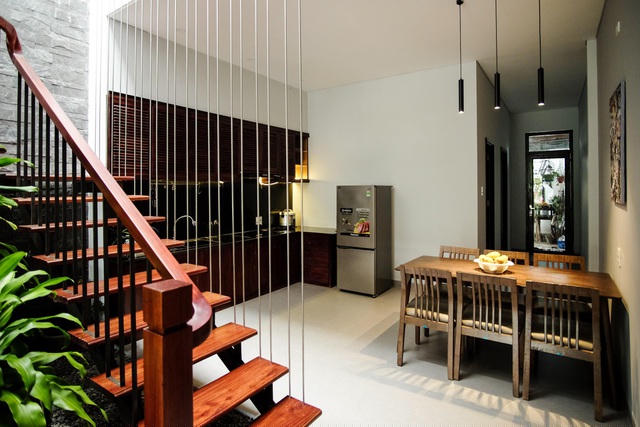 Giữa nhà, khoảng cầu thang kết hợp thông tầng trở thành ranh giới ước lệ giữa phòng khách với phòng ăn, bếp. Anh Luân nhận định đây là