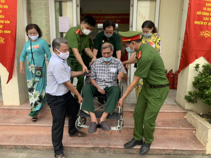 Cán bộ chiến sỹ Công an phường Liên Mạc, quận Bắc Từ Liêm giúp đỡ người khuyết tật trong quá trình tham gia bầu cử