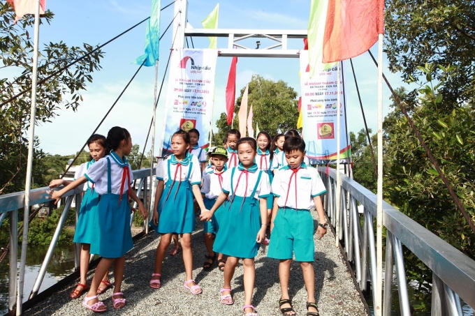 Các em học sinh trường tiểu học Tân Lập tung tăng trên cây cầu thép dây văng.