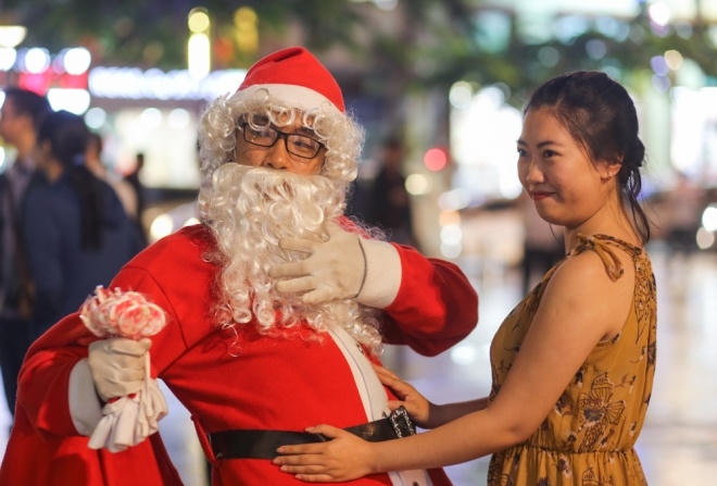 Cũng trên phố đi bộ, các bạn trẻ hóa thân thành ông già Noel để cho du khách chụp ảnh.