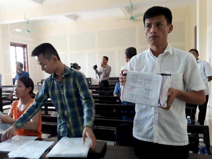 Ông Trần Tử Cường mang hộp hóa đơn bị niêm phong đến tòa.