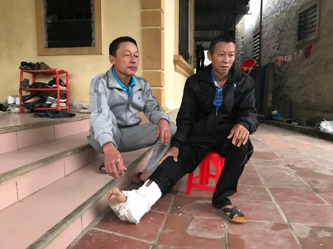 Ông Nguyễn Văn Năng (áo đen) người bị chính con ruột đánh đập đến gãy xương sườn, bầm tím khắp người.