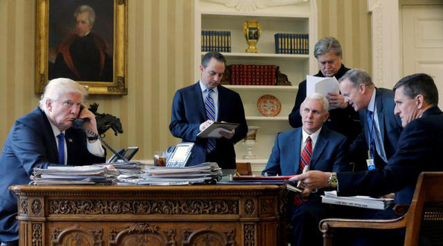Tổng thống Trump điện đàm với Tổng thống Nga Vladimir Putin tại Phòng Bầu Dục. Ngồi xung quanh ông có Chánh Văn phòng Nhà Trắng Reince Priebus, Phó Tổng thống Mike Pence, cố vấn cấp cao Steve Bannon, Giám đốc Truyền thông Sean Spicer và cựu Cố vấn An ninh quốc gia Michael Flynn.