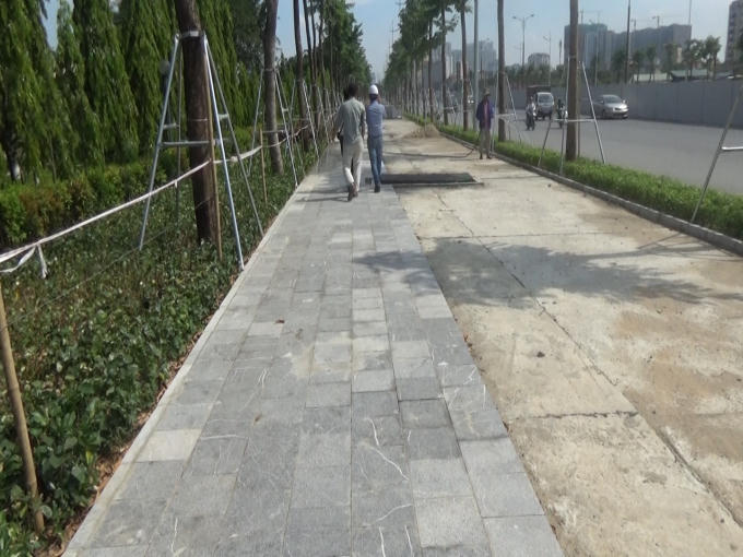 Đường Phạm Văn Đồng - đoạn Công viên Hòa Bình đang được lát đá phần hè đường thuộc Dự án mở rộng đường Vành đai 3 đoạn Mai Dịch - cầu Thăng Long.