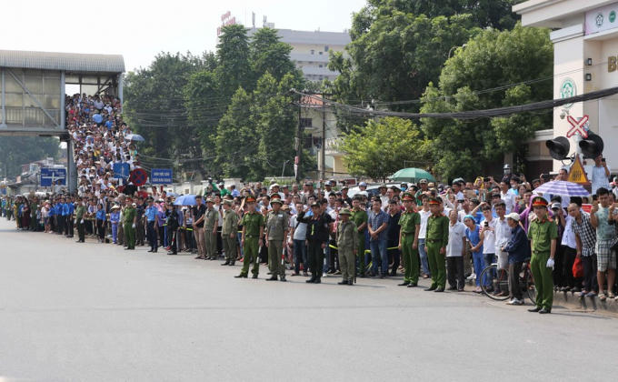 Người dân Thủ đô đưa tiễn linh cữu nguyên Tổng Bí thư Đỗ Mười trên đường Giải Phóng, trước cổng Bệnh viện Bạch Mai. (Ảnh: Dương Giang/TTXVN).