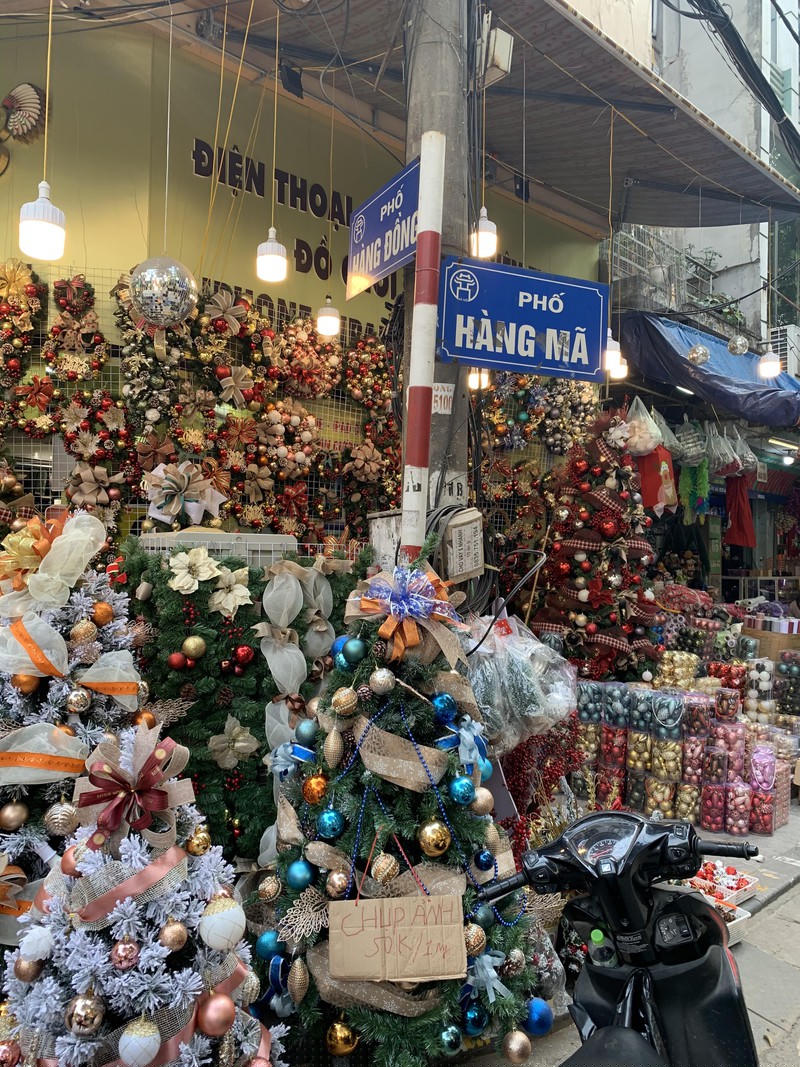 Những chùm chuông và cây thông Noel với nhiều màu sắc và kích cỡ khác nhau cũng được bày bán dọc phố Hàng Mã để thu hút khách hàng.