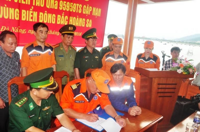 Lực lượng cứu hộ và cơ quan chức năng ký bàn giao các ngư dân về địa phương.