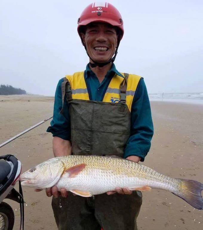 Anh Trương Quang Thắng vui mừng với con cá nghi sủ vàng trên tay.