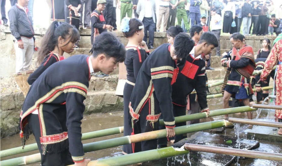 Các chàng trai cô gái lần lượt hứng nước từ bến mang về buôn. Ảnh: Báo Đắk Lắk