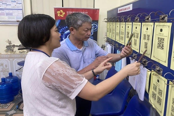 Người dân sử dụng điện thoại thông minh quét mã QR phục vụ tra cứu thông tin thủ tục hành chính.
