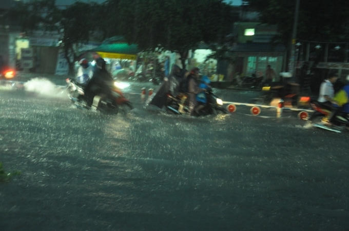 Nước ngập gần hết dải phân cách nhưng mưa vẫn không ngớt.