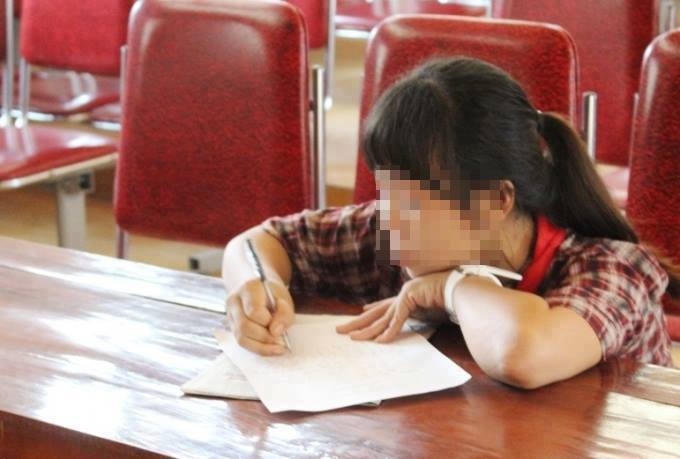 Một trong số các nữ sinh xuất hiện trong đoạn clip viết bản tường trình tại cơ quan chức năng.