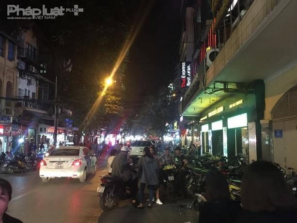 Nhiều người đứng giữa đường chèo kéo khách vào gửi xe.