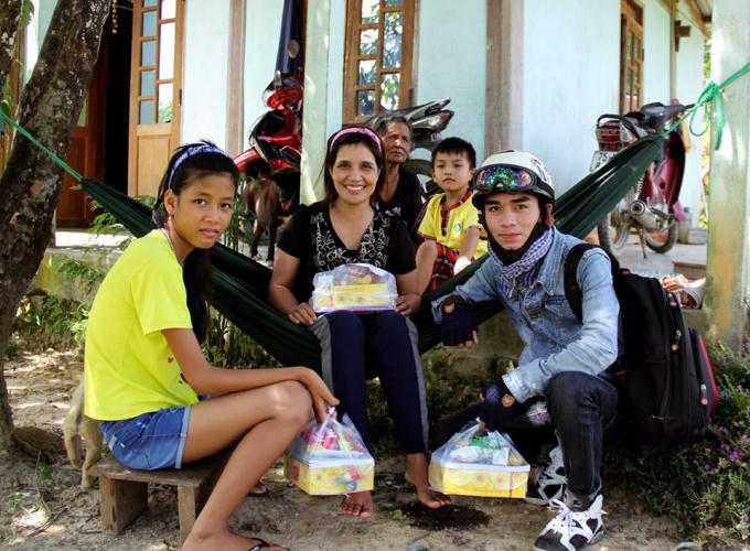 Phóng viên tập sự Hải Long (bên phải) trao quà cho các em nhỏ.