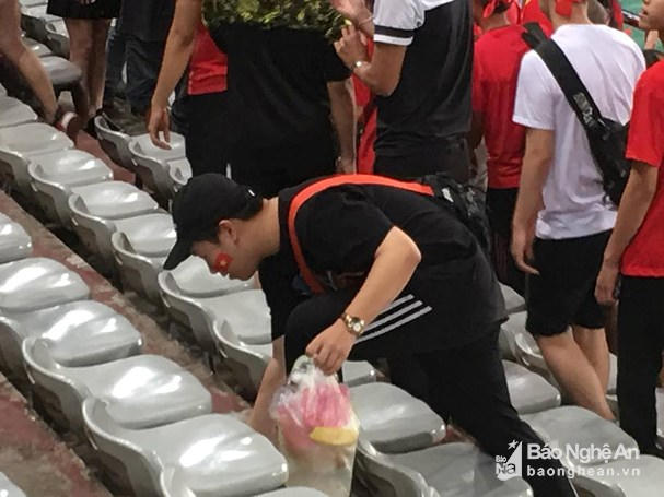 Cổ động viên Việt Nam nán lại dọn rác trên sân vận động. Ảnh: Lang Quốc Khánh