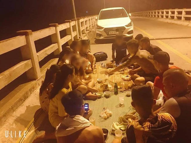 Nhóm thanh niên hồn nhiên trải chiếu ăn nhậu trên cầu.