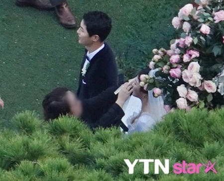 Song Joong Ki trò chuyện với mọi người trong khi cô dâu được dặm lại phấn trang điểm.