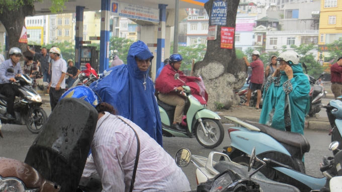 Mặc dù trời mưa to, nhưng hầu hết các bậc phụ huynh đều sẵn sàng đội mưa để cùng con mình trải qua môn thi Toán. (Ảnh: Thu Hường)