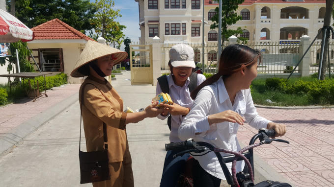 Những phụ nữ tình nguyện viên của nhà chùa phục vụ sữa tận tay cho các em thí sinh.