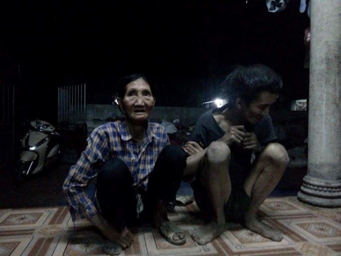 Bà Cần và đứa con bị tâm thần. (Ảnh Huy Trung)