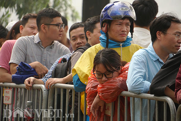 Một cô gái vẫn mặc nguyên áo mưa, tranh thủ chợp mắt giữa dòng người đông đúc. Xung quanh, không ai dám rời khỏi vị trí để đi vệ sinh hoặc uống nước suốt nhiều giờ liền vì sợ mất chỗ.