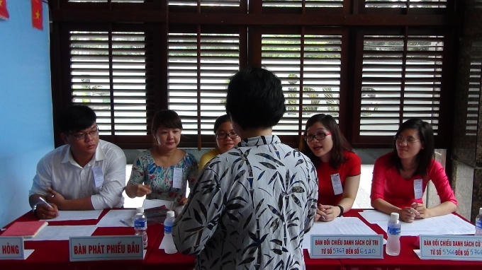 Thành viên tổ bầu cử hướng dẫn cử tri.