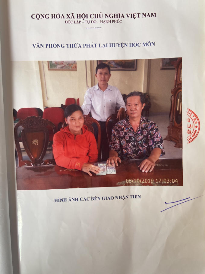 ảnh chụp theo vi bằng, ông Tuân (người ngồi) ký với bà Liên.