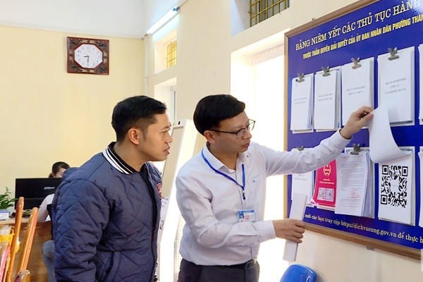 Cán bộ Trung tâm Phục vụ hành chính công phường Thành Nam hướng dẫn người dân tra cứu các thủ tục hành chính.