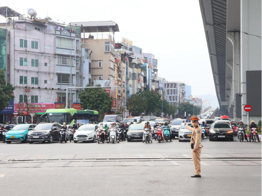 Các phương tiện chấp hành dừng chờ đèn tín hiệu giao thông trên đường Trường Chinh.