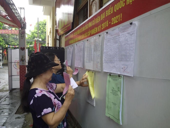 Ngoài trời đang mưa, nhưng cũng không thể khiến các cử tri tới thực hiện quyền và nghĩa vụ của mình. Ảnh Minh Trang