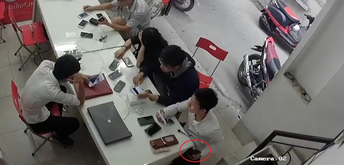Nam thanh niên nhanh tay tuồn chiếc điện thoại xuống dưới bàn và bỏ túi.