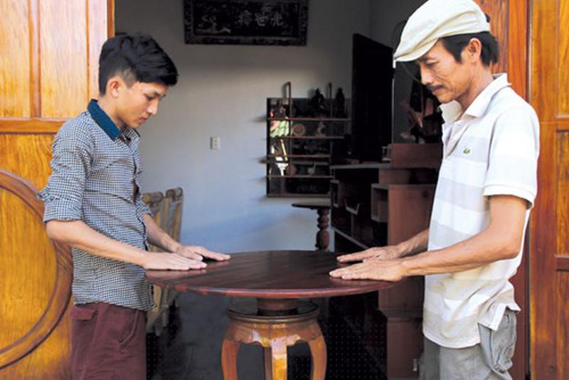 Anh Phạm Miên (bên phải) người kế thừa làm được chiếc bàn tự xoay.  