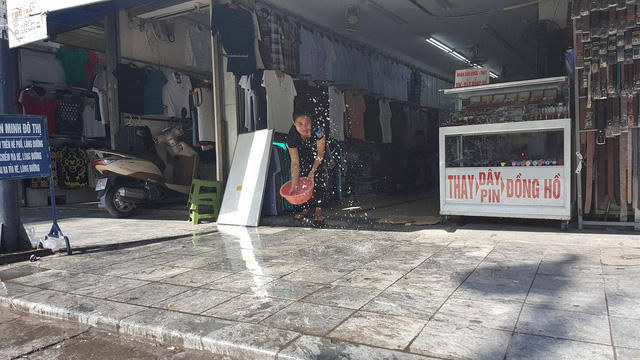 Trên phố Hàng Ngang, các chủ cửa hàng phải liên tục tạt nước để "giảm nhiệt"
