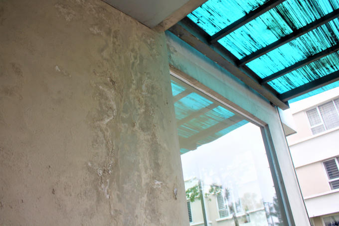 Một mảng tường lớn loang lổ những vết bong tróc do thấm nước.