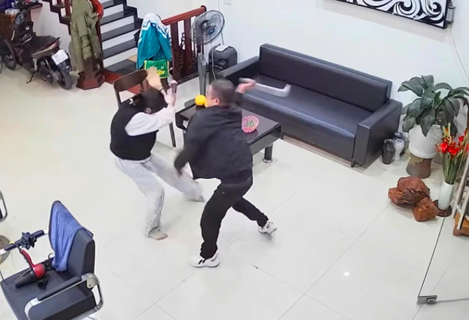 Hình ảnh đối tượng Dương Đăng Thuỵ dùng hung khí tân công vợ và con trong quán cắt tóc. Hình ảnh cắt từ clip.