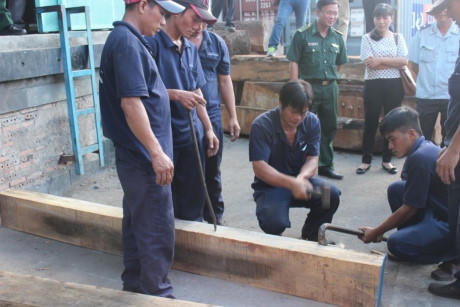 Dùng búa và xà beng phá các khối gỗ.