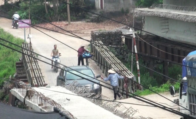 Một nhóm người tự ý lập chốt thu phí đối với ô tô lưu thông qua cây cầu tạm phục vụ công trình xây cầu Hòa Viên. (Ảnh: PV Vietnam+)
