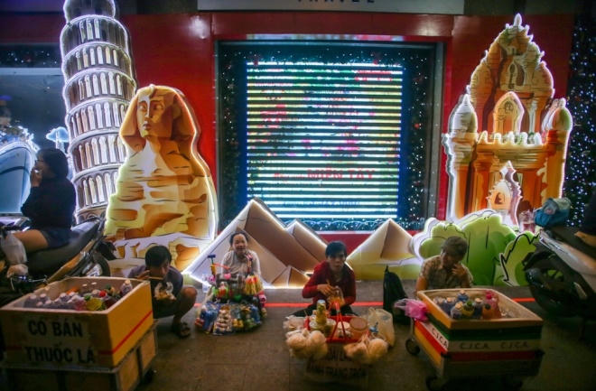 Những người buôn bán trên phố đi bộ trú mưa bên hành lang cửa hàng được trang trí sặc sỡ.