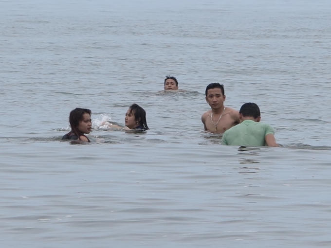 Du khách vẫn vô tư đắm mình trong làn nước biển trong xanh.