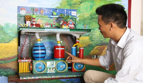 Thầy giáo Phạm Sơn Thu bên mô hình máy thu và xử lý bão trong lòng đất. Ảnh:Phương Vy.