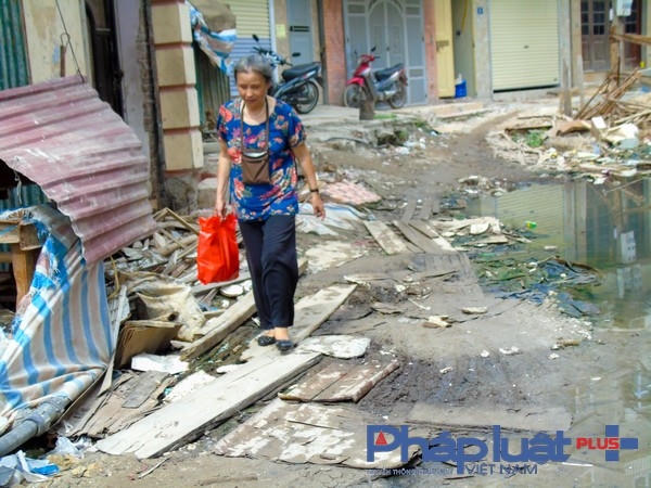 Người dân dùng tấm ván lát lên mặt đường để đi.