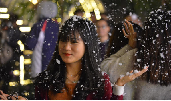 Các bạn trẻ tỏ ra háo hức khi được chứng kiến "tuyết rơi" tại trung tâm Thủ đô.