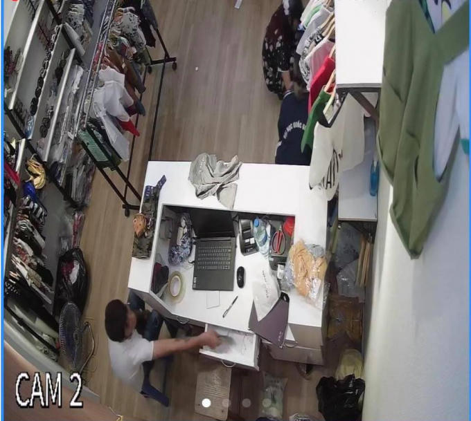 Hình ảnh gã đàn ông thò tay vào ngăn kéo trộm tiền của cửa hàng